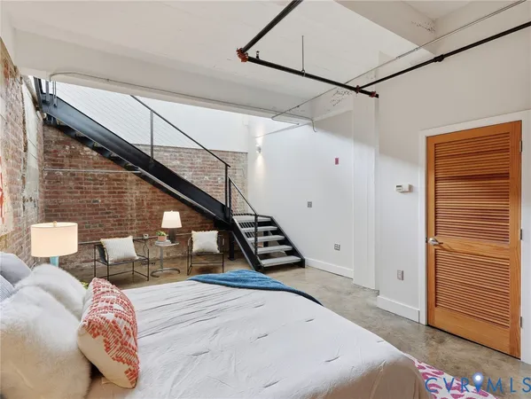 a view of a bedroom with wooden floor and stairs