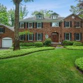 a front view of a house with a yard and potted plants