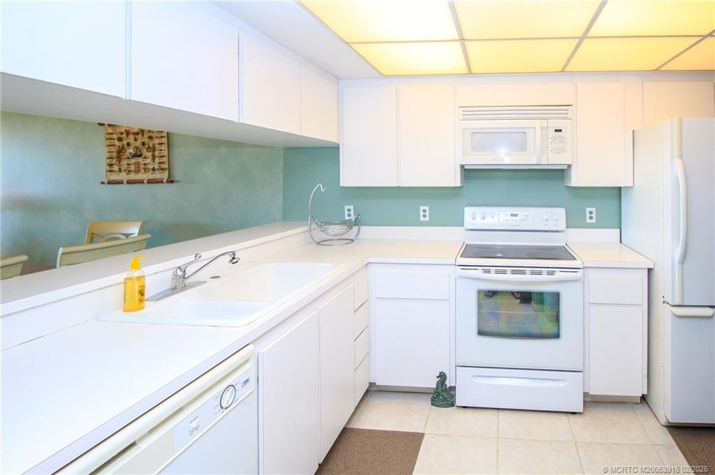 4490 Northeast Sandpebble Trace, Unit 105 Stuart, FL 34996 - Photo 11 of 38 a kitchen with a sink stove and cabinets