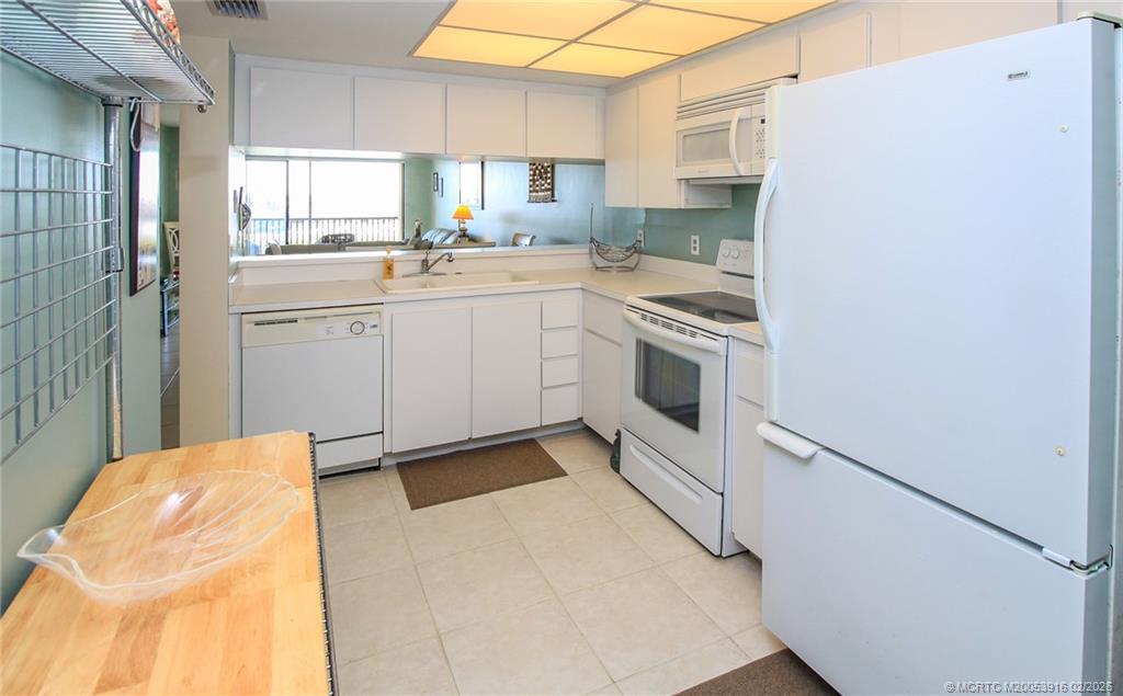 4490 Northeast Sandpebble Trace, Unit 105 Stuart, FL 34996 - Photo 13 of 38 a kitchen with a sink cabinets stainless steel appliances and a window