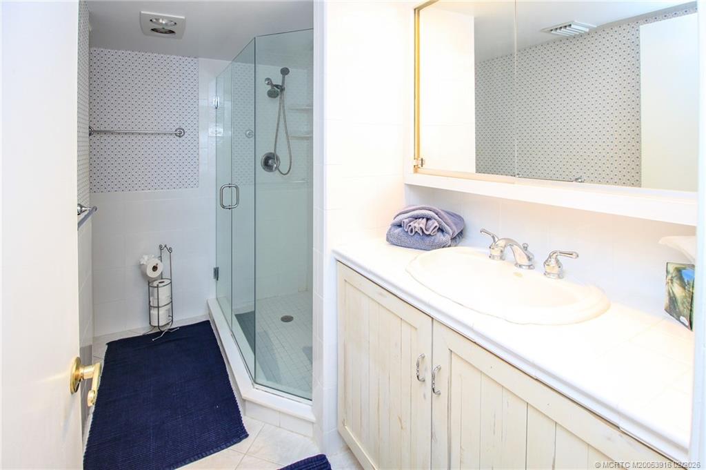 4490 Northeast Sandpebble Trace, Unit 105 Stuart, FL 34996 - Photo 17 of 38 a bathroom with a sink and a mirror