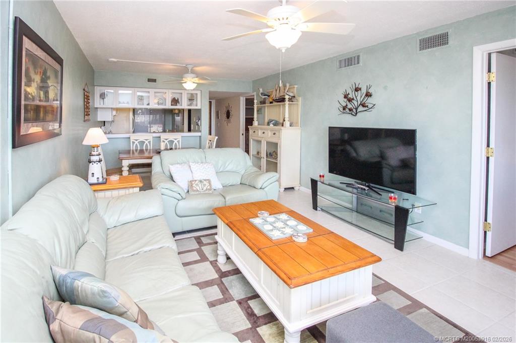 4490 Northeast Sandpebble Trace, Unit 105 Stuart, FL 34996 - Photo 9 of 38 a living room with furniture and a flat screen tv