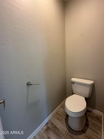 a toilet sitting in a bathroom next to a wooden wall
