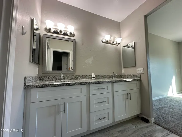 a bathroom with a granite countertop sink and a mirror