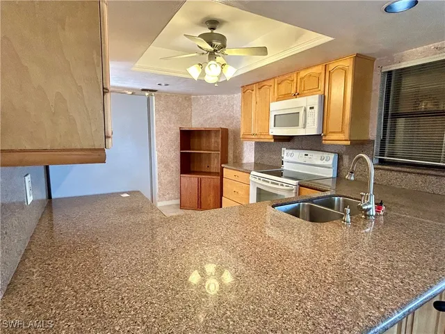 a kitchen with granite countertop a sink stainless steel appliances and cabinets