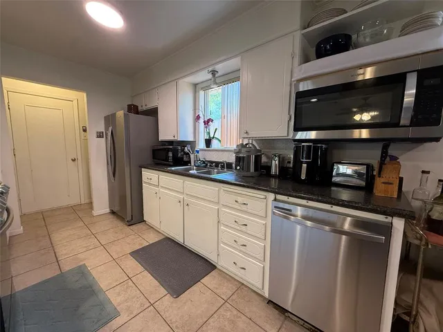 a kitchen with stainless steel appliances kitchen island granite countertop a refrigerator and a stove top oven