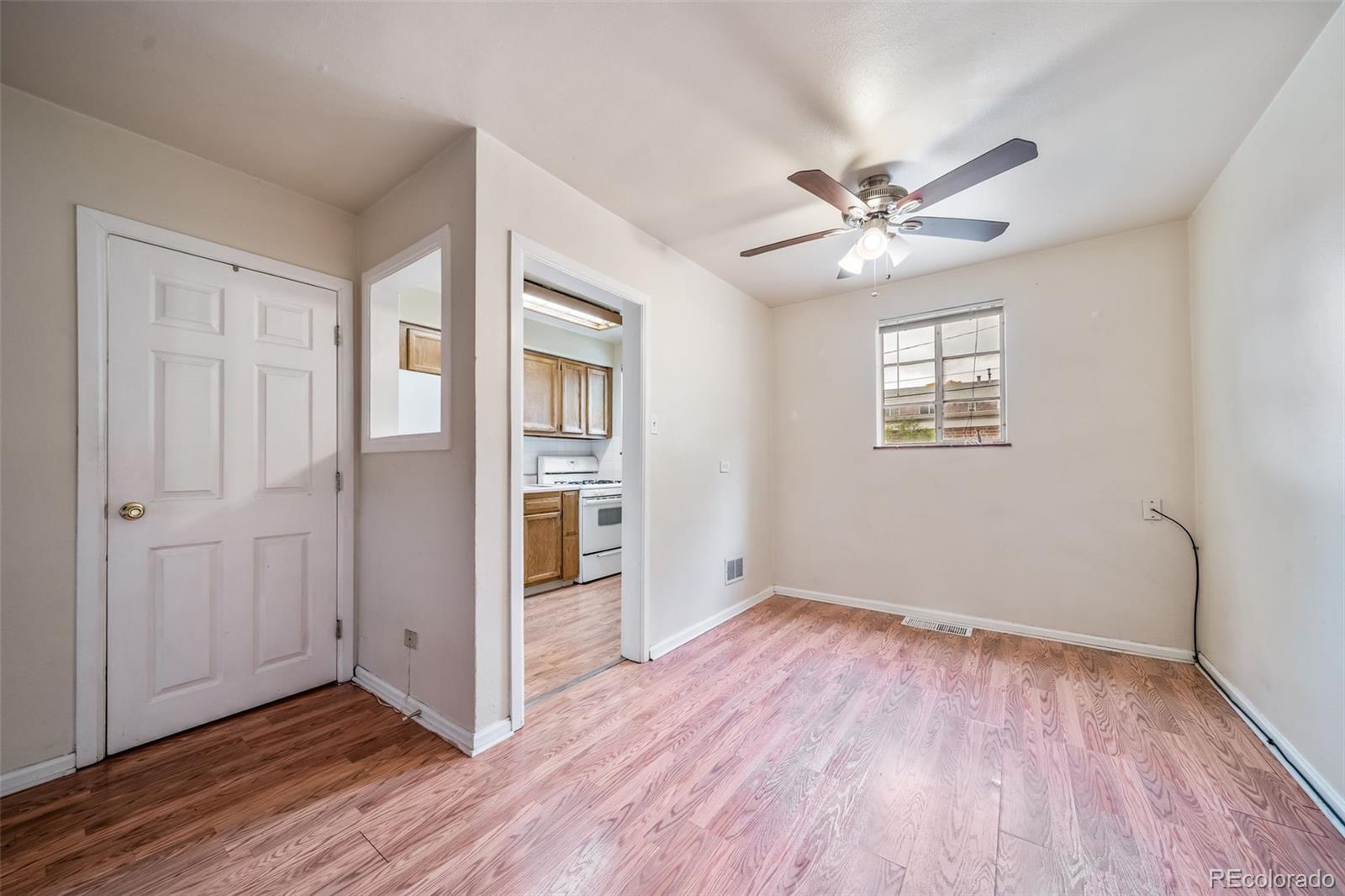 1456 Galena Street Aurora, CO 80010 - Photo 11 of 34 a view of an empty room with a window and wooden floor