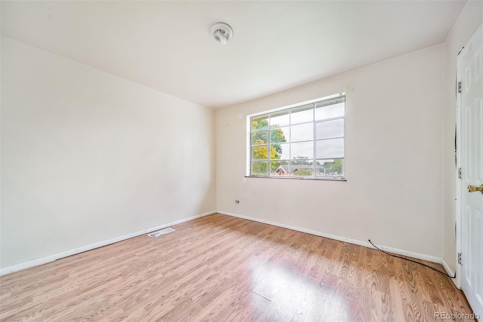 1456 Galena Street Aurora, CO 80010 - Photo 16 of 34 an empty room with wooden floor and windows