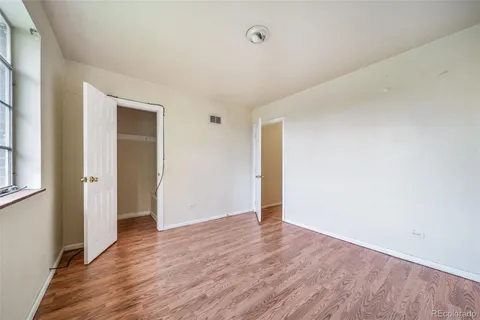 a view of an empty room with wooden floor