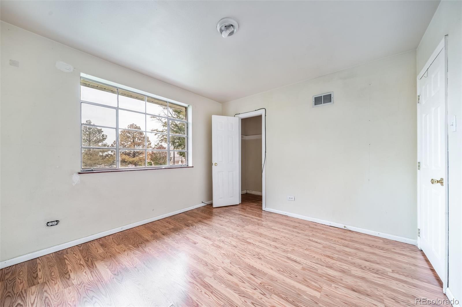 1456 Galena Street Aurora, CO 80010 - Photo 18 of 34 a view of an empty room with wooden floor and a window