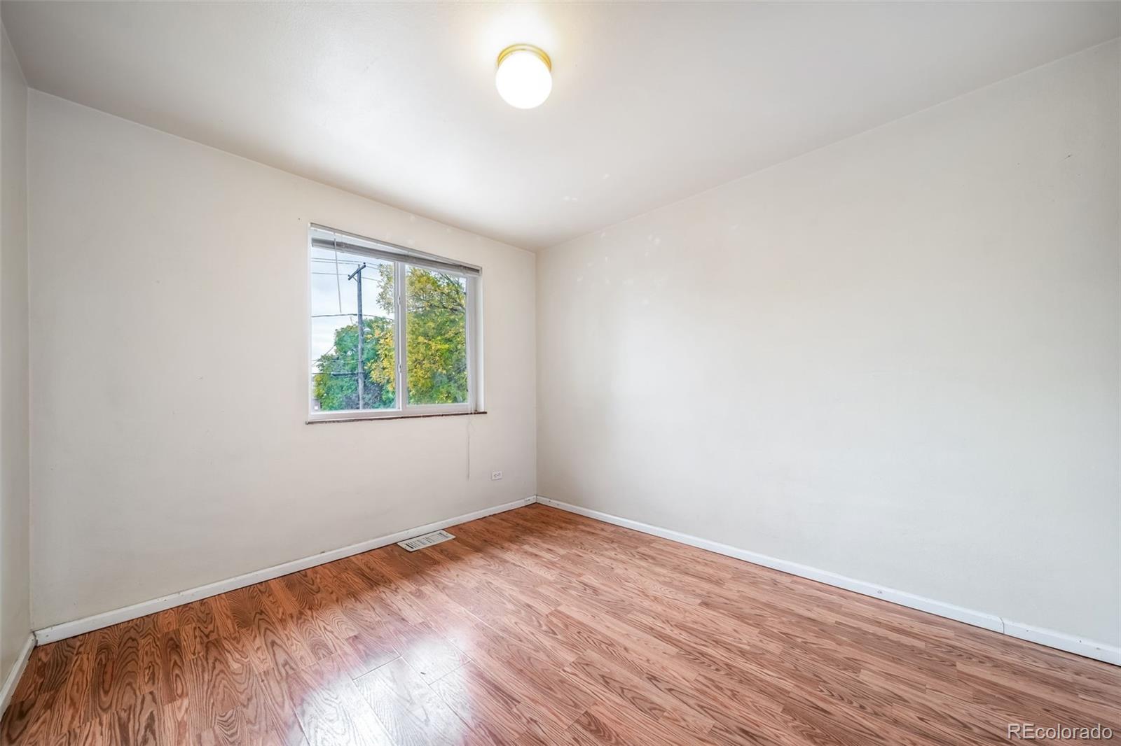 1456 Galena Street Aurora, CO 80010 - Photo 19 of 34 an empty room with wooden floor and windows