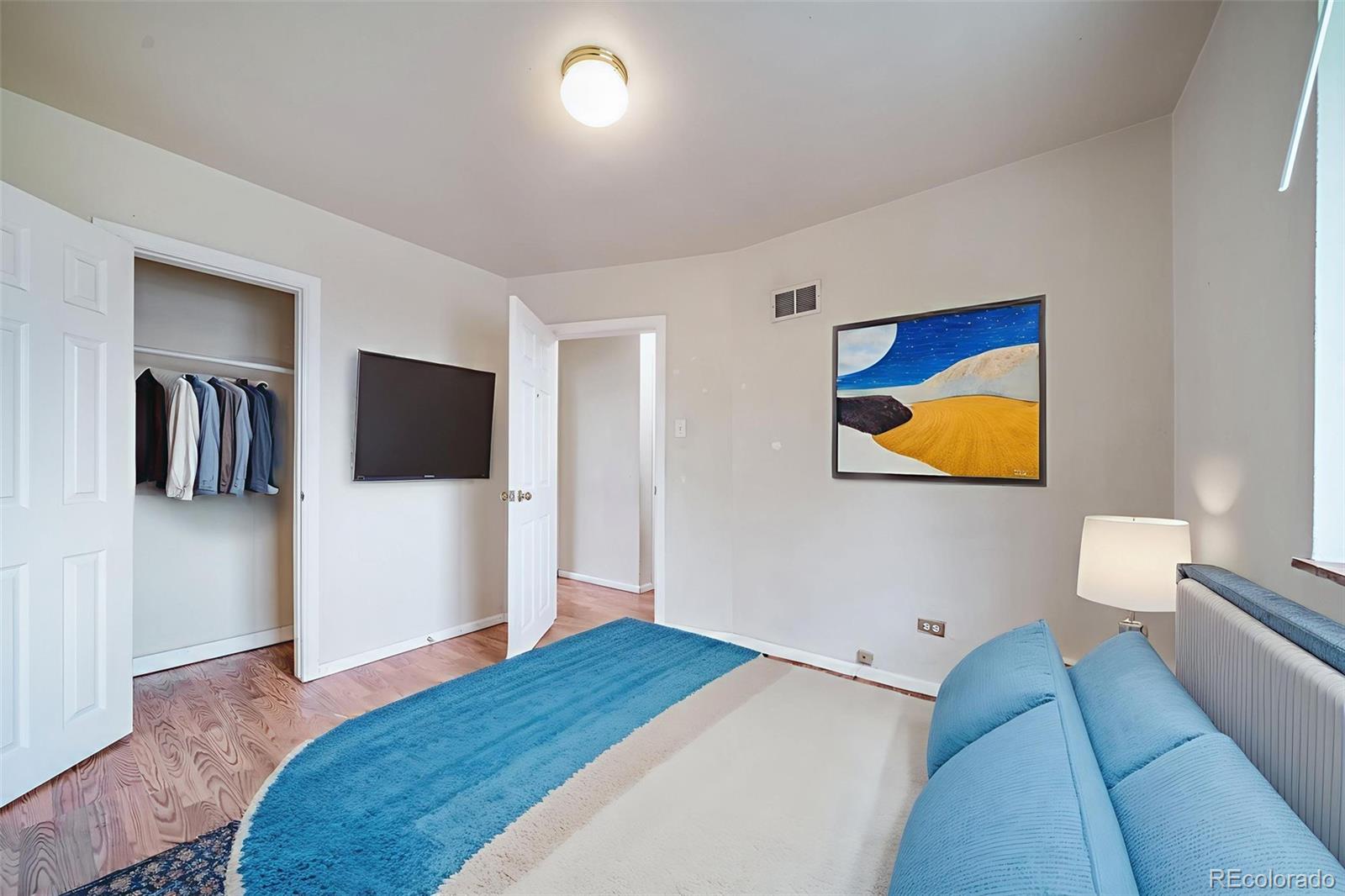 1456 Galena Street Aurora, CO 80010 - Photo 20 of 34 a bedroom with a bed and a flat screen tv