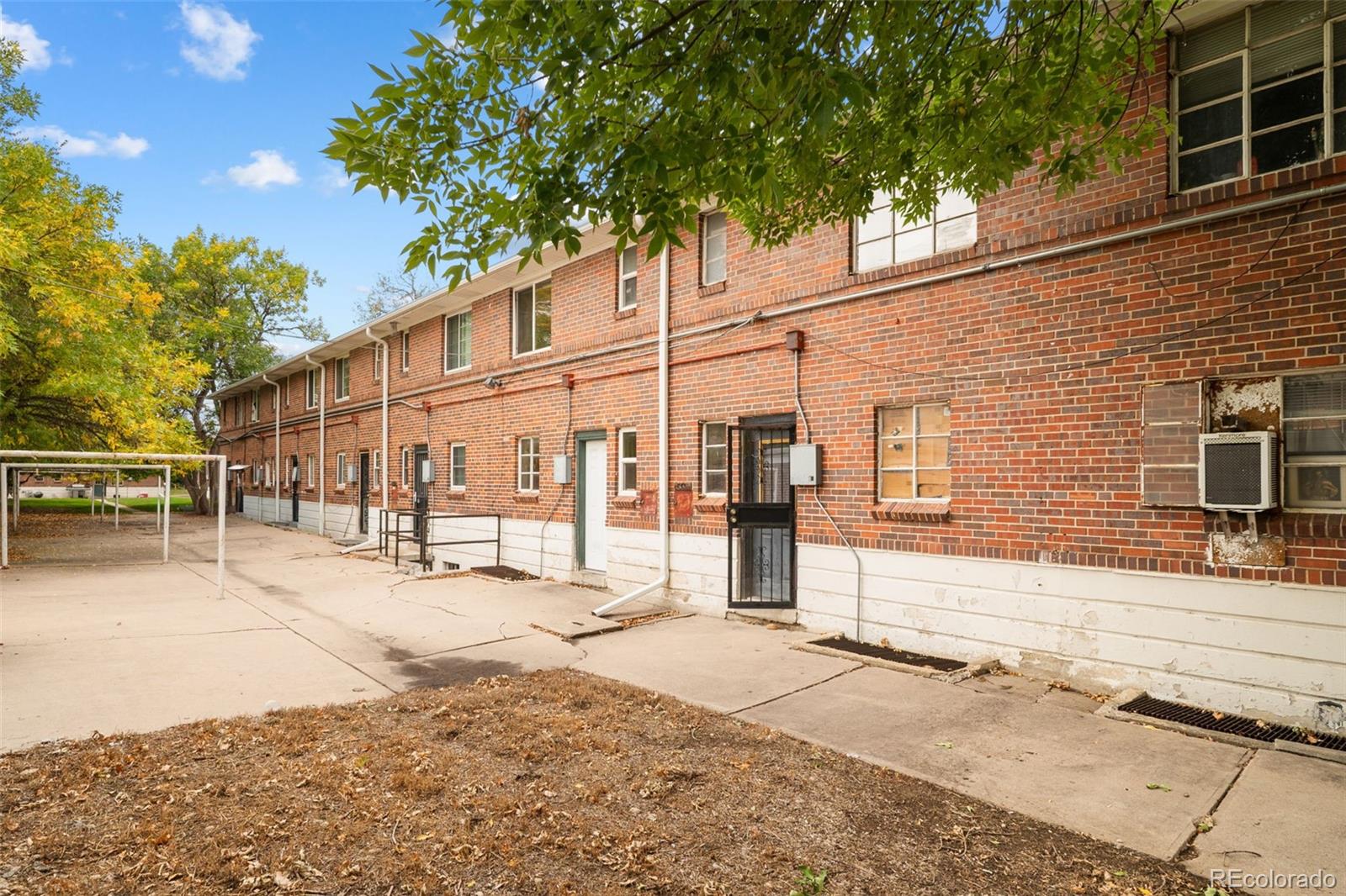 1456 Galena Street Aurora, CO 80010 - Photo 26 of 34 a backyard of a house with large trees and outdoor seating