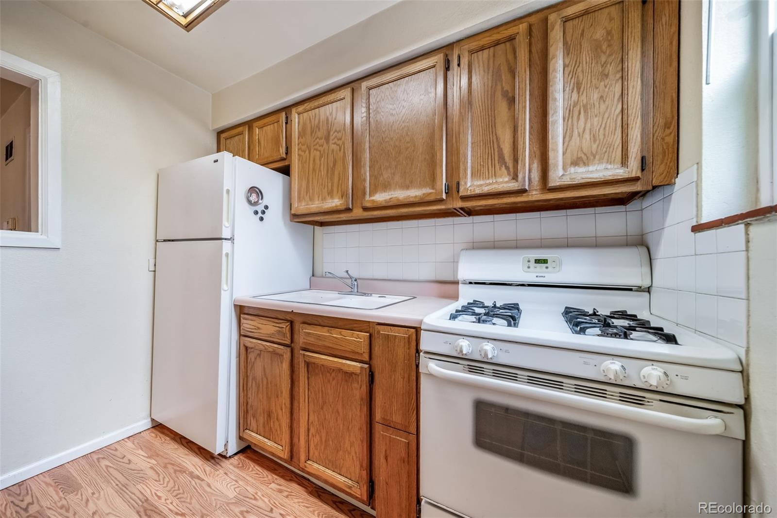 1456 Galena Street Aurora, CO 80010 - Photo 4 of 34 a kitchen with stainless steel appliances white cabinets and a stove top oven