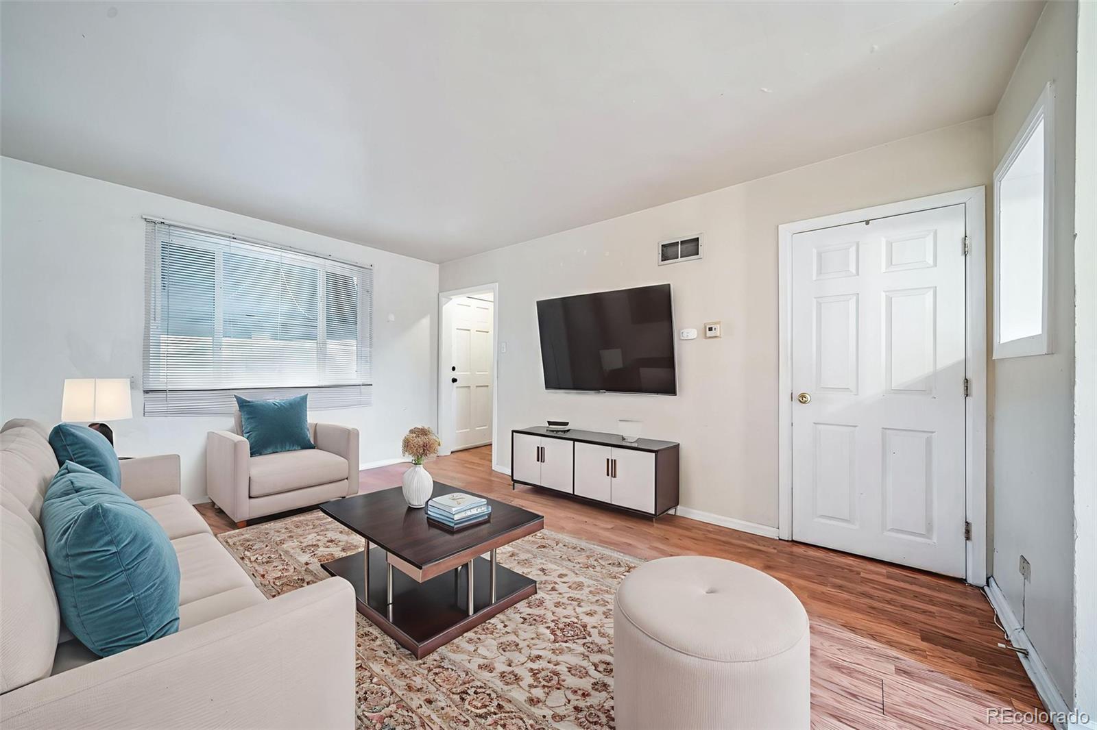 1456 Galena Street Aurora, CO 80010 - Photo 6 of 34 a living room with furniture a flat screen tv and a rug