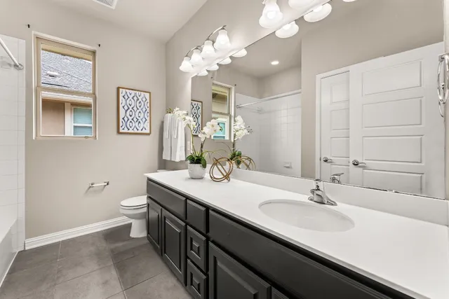 a bathroom with a double vanity sink mirror and toilet