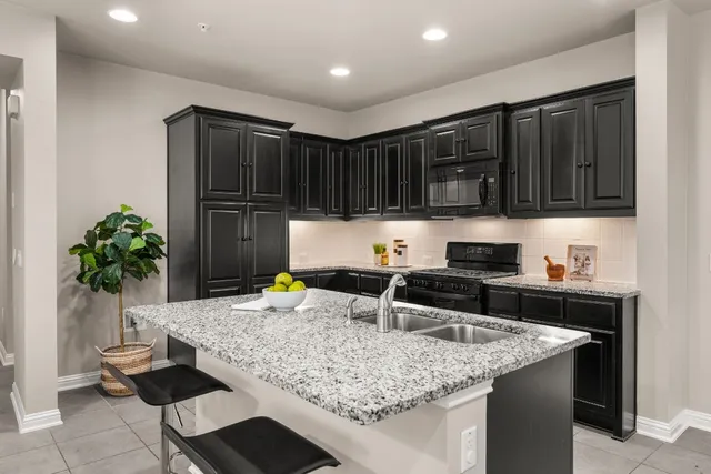 a kitchen with granite countertop a sink and a stove