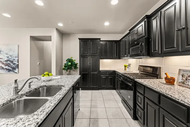 a kitchen with granite countertop a sink stove and cabinets
