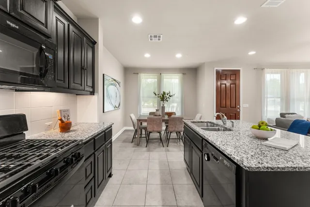 a kitchen with granite countertop lots of counter top space a sink stainless steel appliances and cabinets