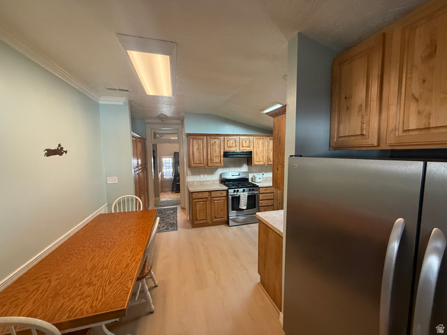 541 300 North Provo, UT 84606 - Photo 24 of 36 Kitchen featuring wood-finish cabinetry, light-toned countertops, and a stainless steel refrigerator