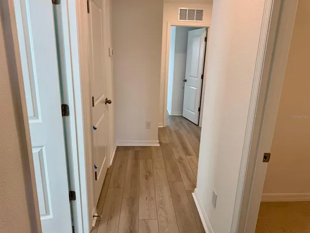 a view of a hallway with wooden floor