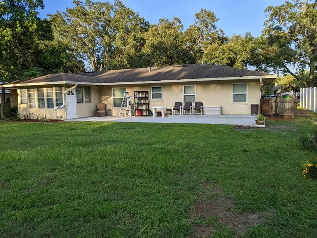 a front view of house with yard barbeque and outdoor seating