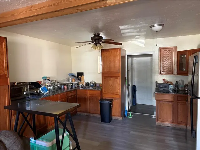 a kitchen with stainless steel appliances a dining table chairs refrigerator and sink