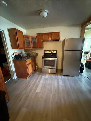 a kitchen with stainless steel appliances a refrigerator a stove a sink and a refrigerator