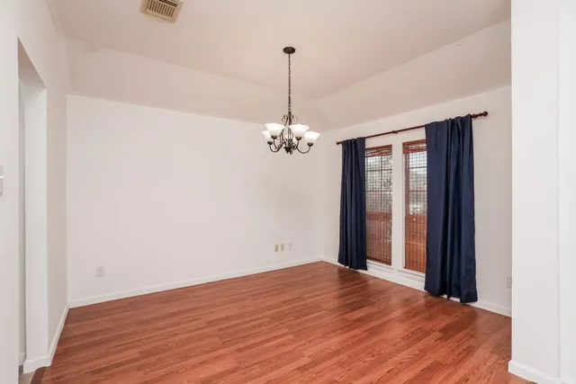 a view of a room with wooden floor chandelier and closet