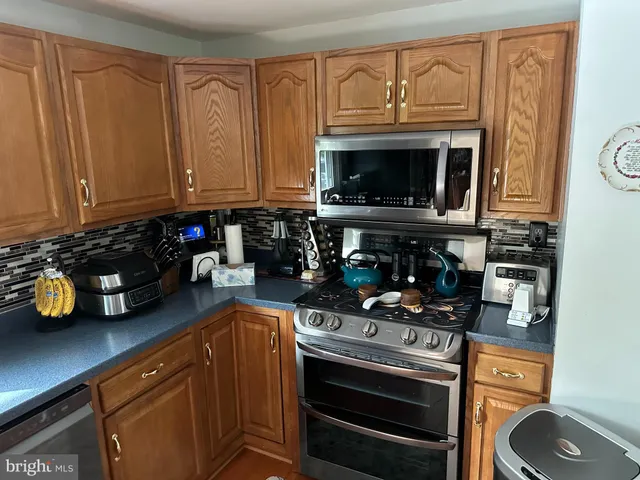 a kitchen with granite countertop a stove top oven microwave and cabinets