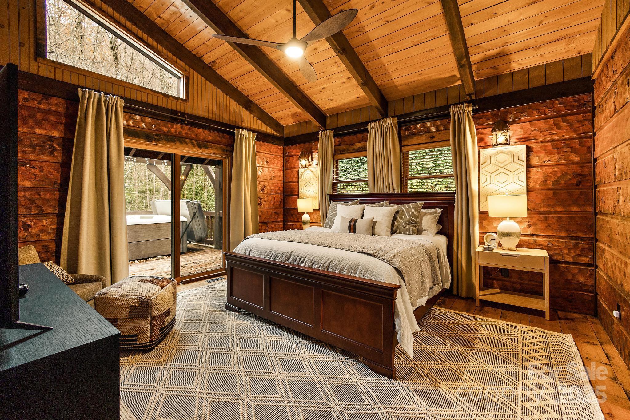 133 Buckeye Ridge Road Beech Mountain, NC 28604 - Photo 14 of 45 a bedroom with a bed and glass door