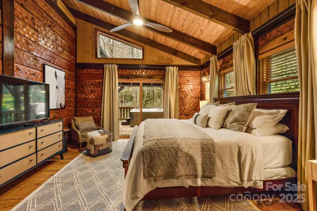 a bedroom with a bed and large windows