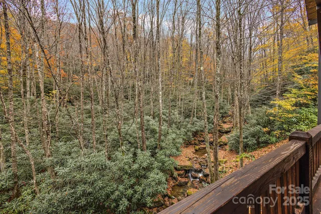 a view of a wooden floor with a bench and trees