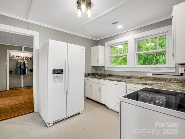 a kitchen that has a sink a window and stainless steel appliances