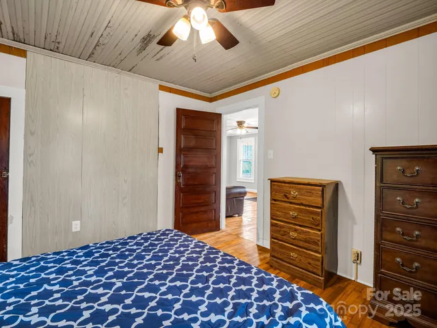 a bedroom with a dresser and a chandelier