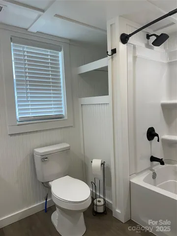 a white toilet sitting next to a window