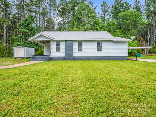 a front view of a house with yard and trees
