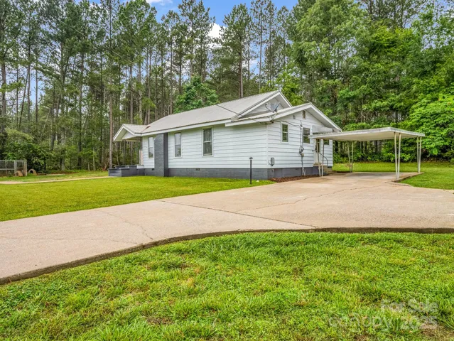 a front view of a house with a garden and yard