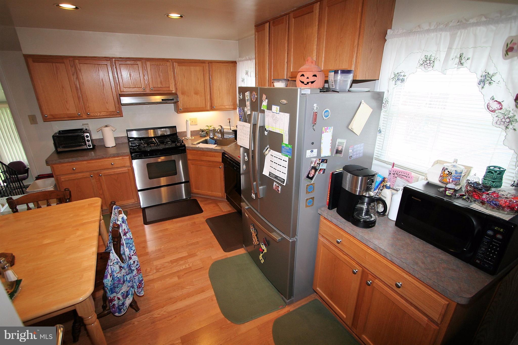 12720 Gould Road Silver Spring, MD 20906 - Photo 7 of 30 a kitchen with stainless steel appliances granite countertop a refrigerator stove top oven and sink