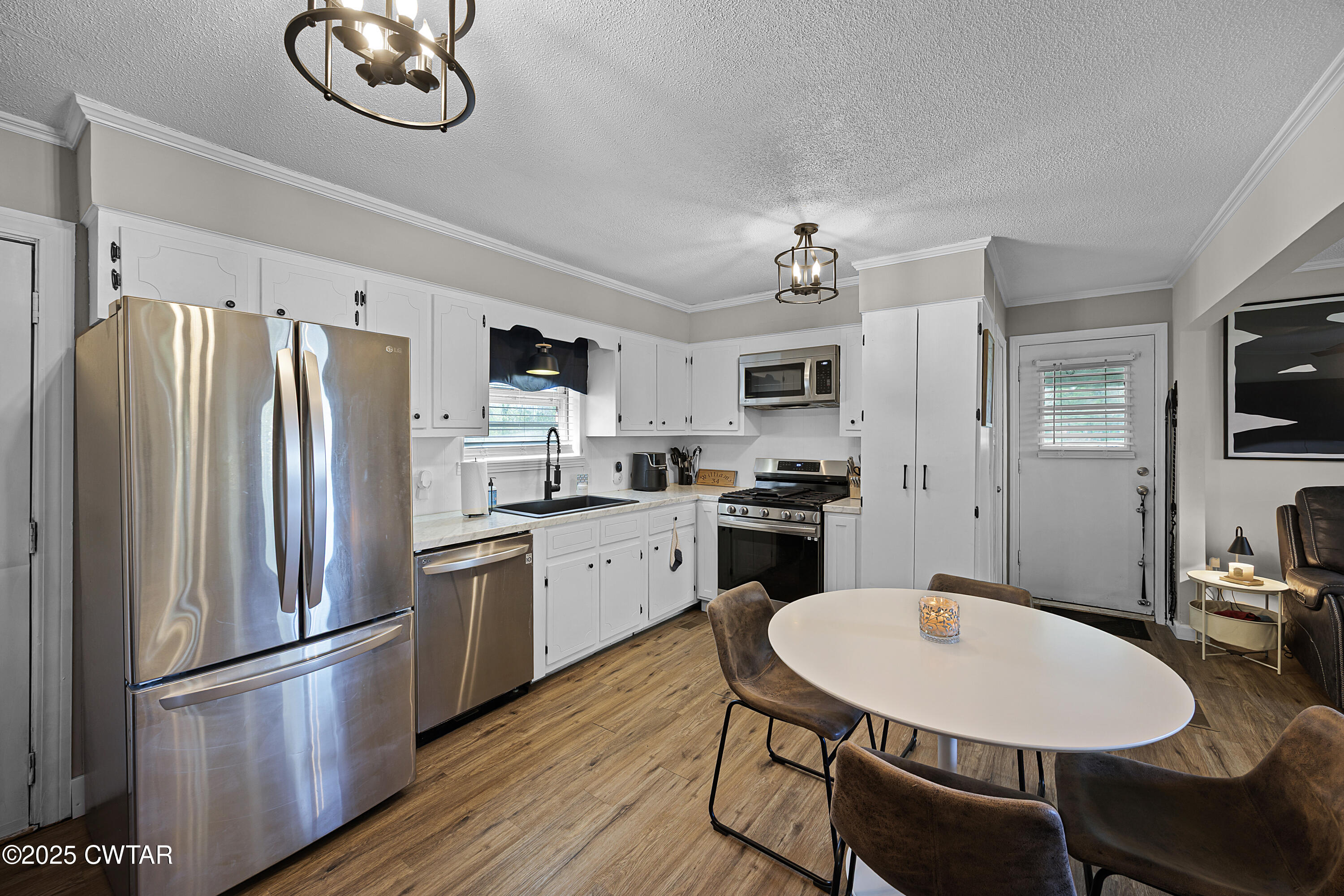 34 Hughes Loop Milan, TN 38358 - Photo 7 of 21 a kitchen with stainless steel appliances a refrigerator a stove a sink a dining table and chairs