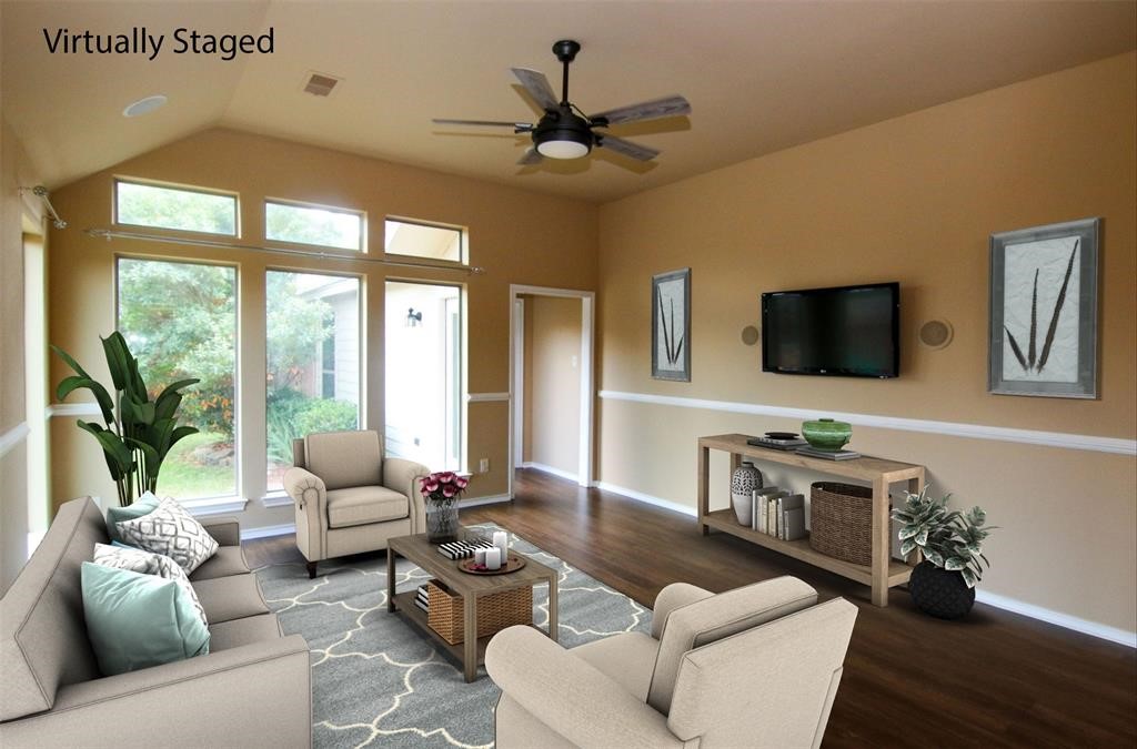 a living room with furniture flat screen tv and a large window