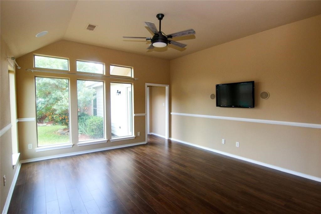 27431 Rebecca Field Lane Spring, TX 77386 - Photo 11 of 26 a view of an empty room with wooden floor and a window