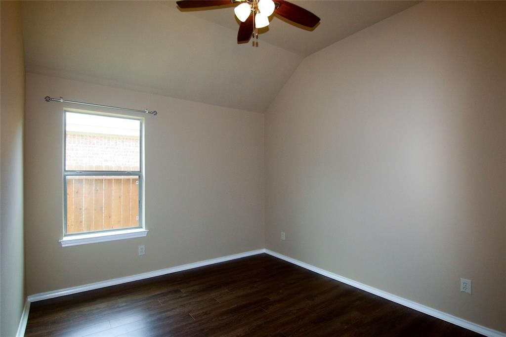 27431 Rebecca Field Lane Spring, TX 77386 - Photo 20 of 26 an empty room with wooden floor chandelier fan and windows