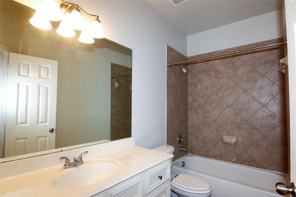 27431 Rebecca Field Lane Spring, TX 77386 - Photo 21 of 26 a bathroom with a granite countertop sink toilet and shower