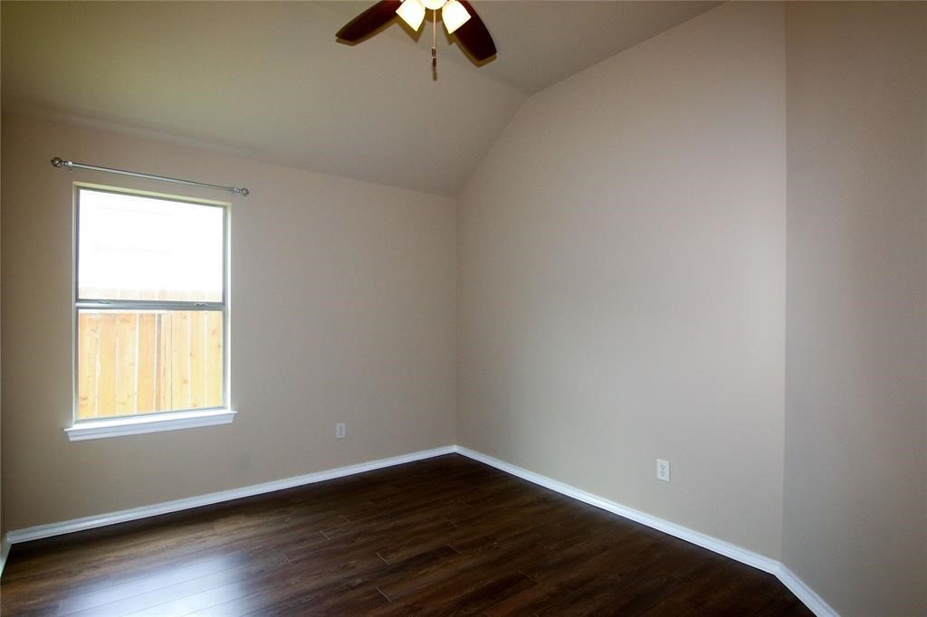 27431 Rebecca Field Lane Spring, TX 77386 - Photo 22 of 26 an empty room with wooden floor chandelier fan and windows