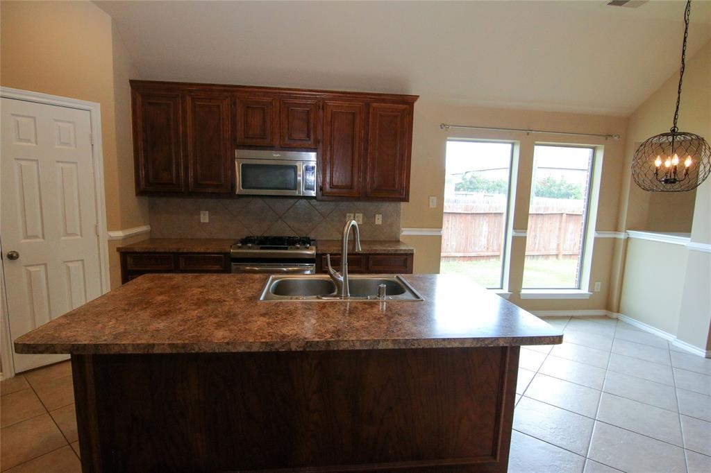 27431 Rebecca Field Lane Spring, TX 77386 - Photo 6 of 26 a kitchen with a sink a microwave a stove and refrigerator