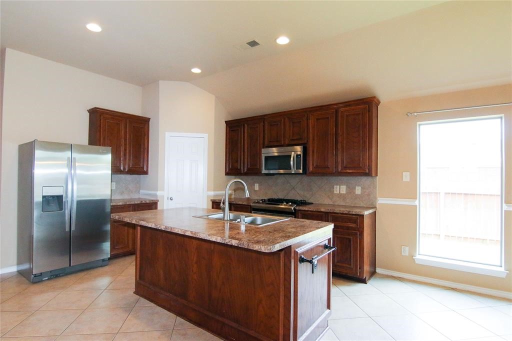 27431 Rebecca Field Lane Spring, TX 77386 - Photo 7 of 26 a kitchen with stainless steel appliances granite countertop a sink stove and refrigerator