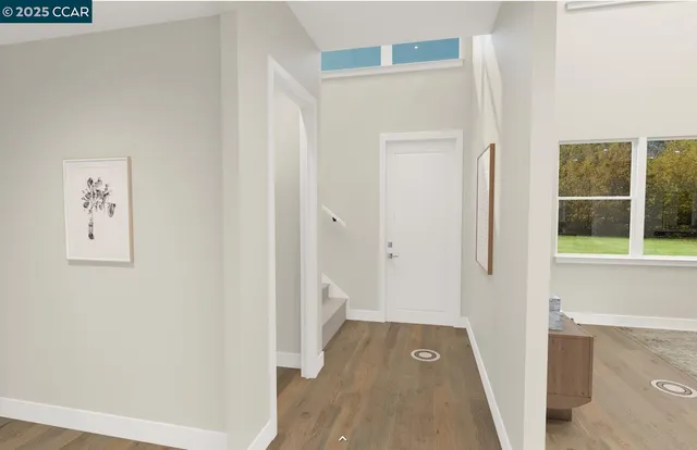 a view of a hallway with wooden floor and a bathroom