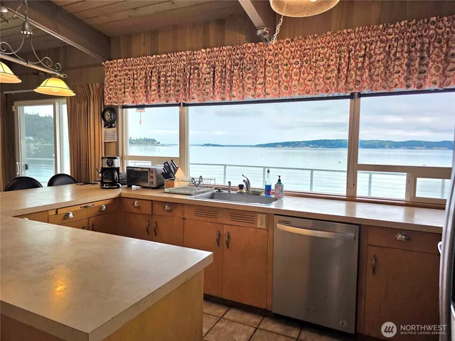 a kitchen with stainless steel appliances granite countertop a sink a stove and a microwave