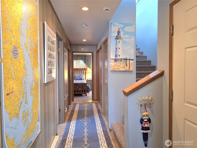 a view of a hallway with wooden floor and windows